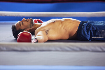 Canvas Print - Looks like a knockout. Cropped shot of a handsome young male boxer lying in the ring with his eyes closed after a fight.