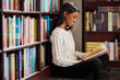 © Lumeez Ismail/peopleimages.com - This is quite an exciting chapter. Shot of a young woman reading a book while sitting on the floor against a bookshelf in a library.
