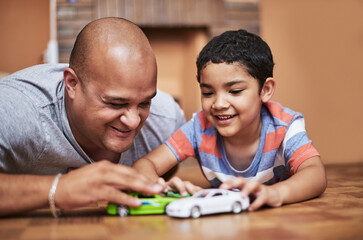 Sticker - Boys love their cars. Cropped shot of a cheerful little boy and his father playing with toy cars while being seated on the floor at home during the day.