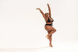 Full photo of happy, wonderful plus size African girl wearing black fashionable swimsuit, laughing and dancing.Concept of body acceptance, body positivity