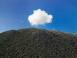© SuperStock - Pile of small stones against blue sky and lone white cloud in blue sky