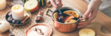 Young Woman Preparing Hot Autumn Drink: Mulled Wine With Spices, Fruits. Natural Ingreduents: Cinnamon, Anise, Cardamon, Clove, Apple, Orange. Cozy Home Atmosphere Banner