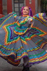 Wall Mural - Young Mexican woman in a traditional folklore dress of many colors, traditional dancer.