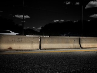 Simple Cement Concrete Barrier Structure protecting 2 way traffic blocking road at construction site with rock texture on blackened background Roadblock