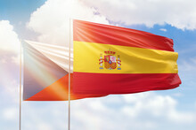 Sunny blue sky and flags of spain and czechia