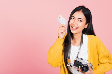 Wall Mural - Happy Asian portrait beautiful young woman excited smiling photographer holding credit credit card bank and retro vintage photo camera ready travel isolated on pink background, tourism and vacation