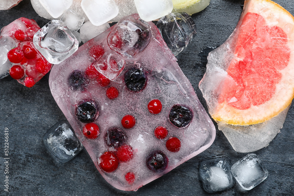 Fresh fruits frozen in ice on black background