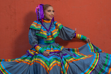 Wall Mural - Portrait of a Mexican woman wearing a traditional dress for folk dance
