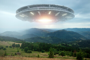 Wall Mural - ufo, an alien saucer hovering over the mountains in the clouds, hovering motionless in the sky. unid
