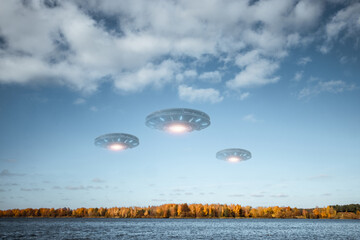 Wall Mural - ufo, an alien saucer hovering above the lake in the clouds, hovering motionless in the sky. unidenti