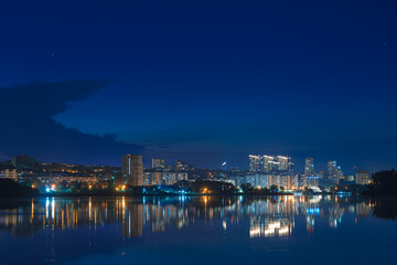 Beautiful view of the night city. Right bank of the Dnieper, lights in the night river. View of beautiful modern buildings.