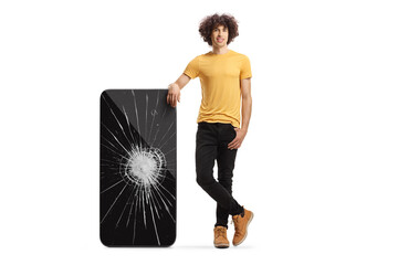 Sticker - Young man with curly hair stanging next to a smartphone with crushed screen