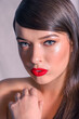 Close-up of a Beautiful Caucasian Woman With Cat Blue Eyes, Full Red Lips and Open Mouth, Touching Her Shoulder, on Grey Background