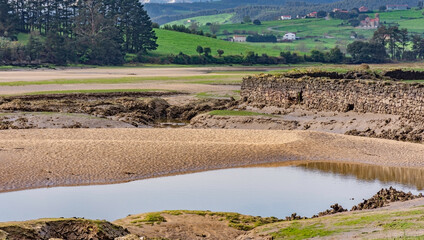 Wall Mural - estuary landscape with low tide and blue sky with clouds