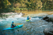 Two Whitewater Kayakers Paddling On The Waters Of River. Adrenaline Seekers And Nature Lovers.