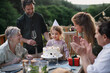 © Halfpoint - Multi generation family celebrating birthday of little girl and having garden party outside on patio.