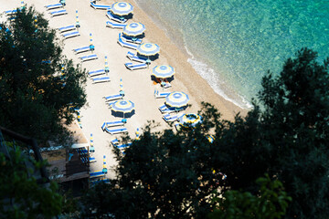 Wall Mural - View from above, stunning aerial view of some beach umbrellas on a beautiful beach bathed by a crystal clear water. Amalfi Coast, Italy.