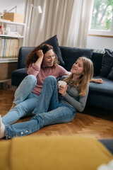 Wall Mural - mother and teenager daughter talking at home. sitting on floor in living room