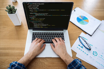 software concept. top view of male hands on laptop keyboard, it specialist, programmer, uses laptop,