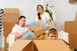 © fotofabrika - Parents and son packing boxes and moving into a new home