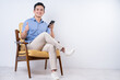 © Timeimage - Image of young Asian man sitting on chair