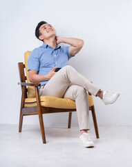 Canvas Print - Image of young Asian man sitting on chair