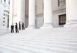 © DW labs Incorporated - Four people in discussion on the exterior steps of a courthouse. Could be lawyers, business people etc.