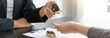 © Puwasit Inyavileart - Car salesman gave the keys to the customers who signed the purchase contract legally, Successful completion of car sales, Purchase contract and key delivery.