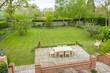 Large landscaped back garden with patio furniture, UK