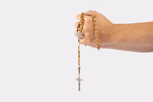 Folded Hands Of A Young Man Holding A Rosary During A Pray Isolated On White Background