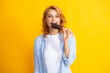 Portrait of beautiful woman eating ice cream on orange yellow background. Girl eating popsicle ice pop. Happy excited expression female portrait.