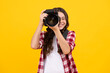 © Olena - Teenager lifestyle, teen hipster hold professional camera. Girl with photo camera photographing, isolated on studio background. Happy teenager, positive and smiling emotions of teen girl.