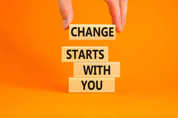 Wall Mural - Change starts with you symbol. Concept words Change starts with you on wooden blocks on beautiful orange table orange background. Businessman hand. Business motivational change starts with you concept