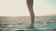 Close up woman wearing leggings standing on yoga mat. Close up female legs on beach