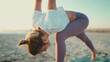 Close up woman stretching preparing her body for yoga on the beach. Female yogi practicing outdoors. Fit woman body