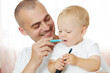 Father teaching baby boy brushing teeth. The concept of oral hygiene from the first tooth