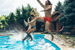 © BalanceFormCreative - A young group of friends jumping into the swimming pool.Having fun and refreshing on a hot summer day.