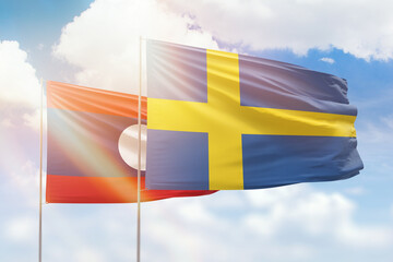 Sunny blue sky and flags of sweden and laos