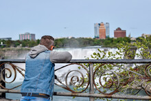 Middle Aged Man From Behind Standing At Niagara Falls Barrier Railing During Travels