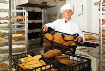 Wall Mural - Portrait of baker with fresh bread at the bakery