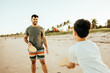 © kleberpicui - Father and son having fun on the beach during summer vacation playing beach tennis