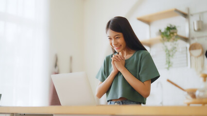 Funny euphoric young asian woman celebrating winning or getting ecommerce shopping offer on computer laptop. Excited happy girl winner looking at notebook celebrating success