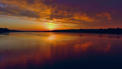 Wall Mural - Spectacular red dawn sky mirrored in tranquil waters, dynamic moving perspective.
