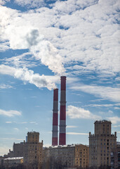 Poster - CHP in the city. Smoke rises into the sky from the heat pipes of the power plant. Pipe of combined heat and power plant CHP or cogeneration against background of multi-storey residential buildings