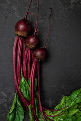 Sticker - Raw beetroot. Organic red beetroot with herbage green leaves on a dark background. vertical image. top view. place for text