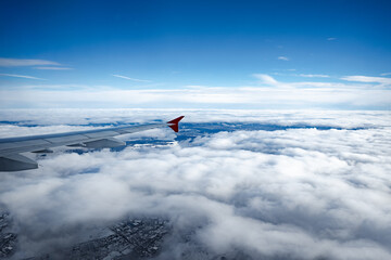 Wall Mural - aircraft wing above beautiful clouds and blue sky