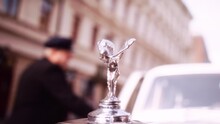 Close-up Bokeh Shot Of Rolls Royce Emblem On Car Hood