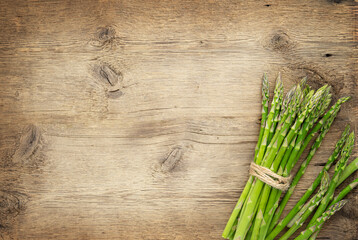 Wall Mural - Bunch of green asparagus on wooden background. Copy space