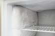 A lot of frost and ice in the freezer of the refrigerator. Poor quality of the freezing chamber. Selective focus on the foreground.