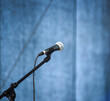 Auf einer Bühne steht ein während einer Pause ungenutztes Mikrofon.